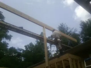 Carpenter setting a ridge beam over a new addition frame — Ice Dam Removal by Roofing Brothers in Jefferson City